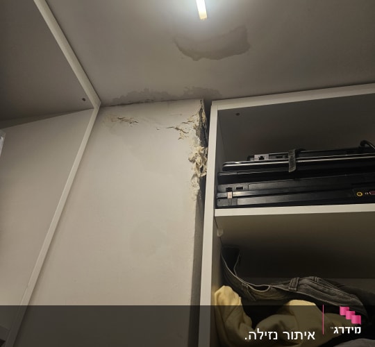 נזקי רטיבות בתקרה ובקיר ליד ארון בגדים